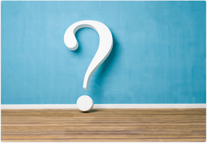 Large white question mark in front of a blue wall and wooden floor